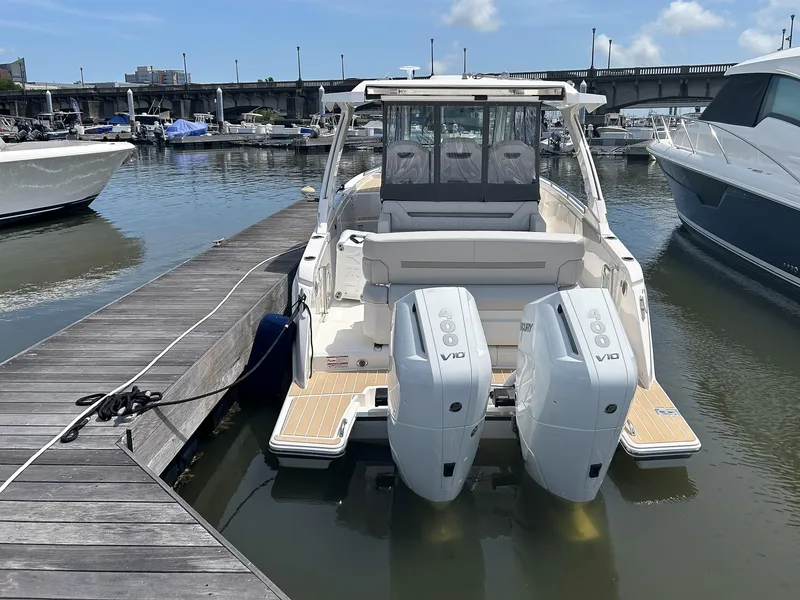 Slide: The Image of 2025 Tiara Yachts 34 LS docked with dual outboard engines, sunny marina setting. - 4