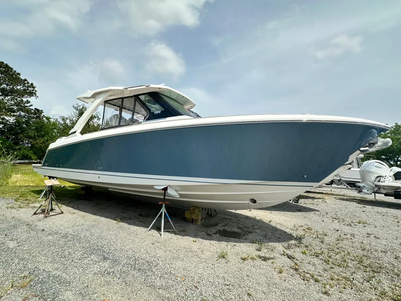 Slide: The Image of 2025 Tiara Yachts 34 LS boat on stands, blue hull, outdoor setting. - 8