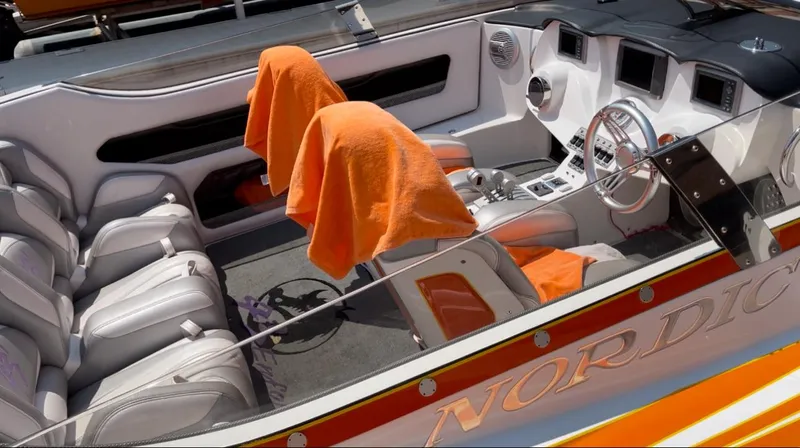 Slide: The Image of 2014 Nordic Powerboats 43 Enforcer interior with orange accents and modern dashboard. - 7