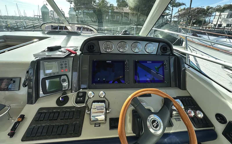 Slide: The Image of 2006 Sea Ray 48 Sundancer helm with navigation screens and controls. - 11