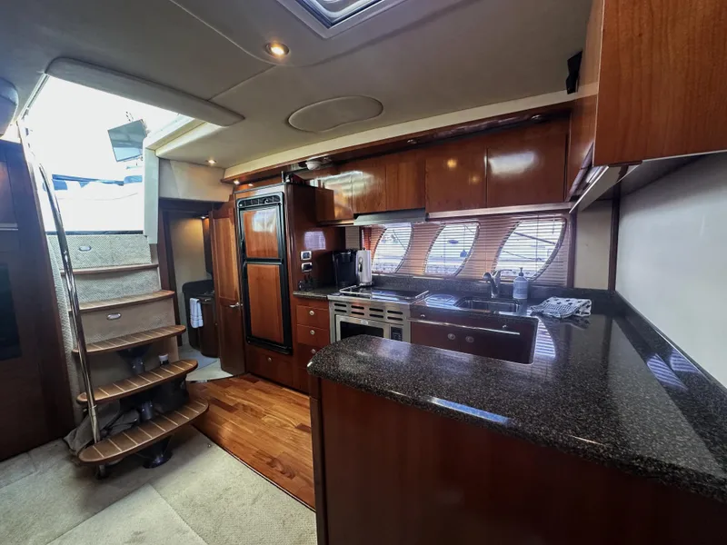 Slide: The Image of Interior of 2006 Sea Ray 48 Sundancer yacht with modern kitchen and wooden cabinetry. - 15