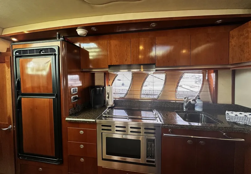 Slide: The Image of Luxurious kitchen interior of 2006 Sea Ray 48 Sundancer yacht with wood cabinetry. - 18