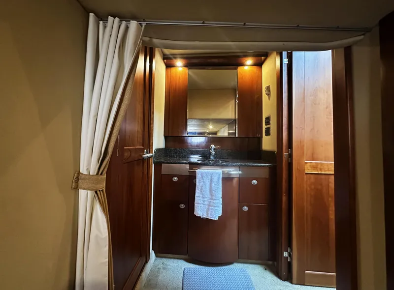 Slide: The Image of 2006 Sea Ray 48 Sundancer interior with wooden cabinetry and sink area. - 25
