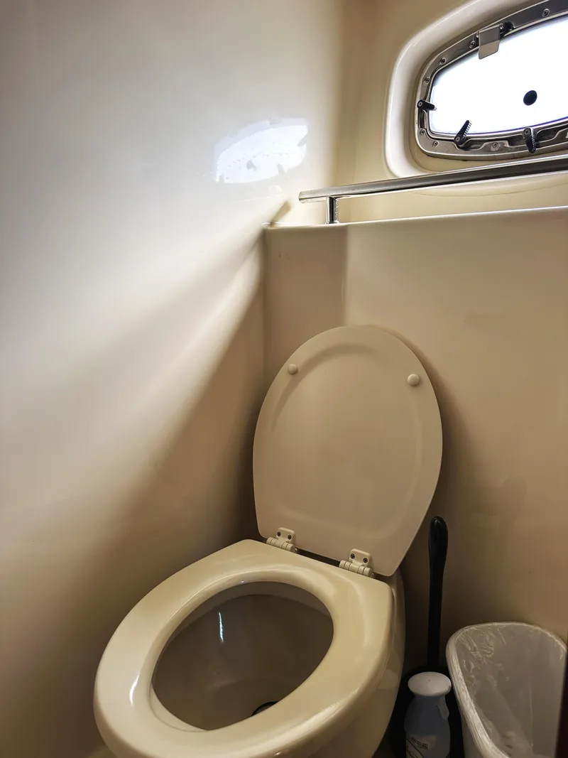 Slide: The Image of Bathroom interior of 2006 Sea Ray 48 Sundancer yacht with toilet and porthole. - 26