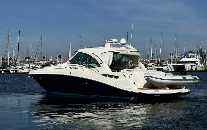Slide: The Image of 2006 Sea Ray 48 Sundancer yacht docked in marina, calm waters, clear sky. - 3