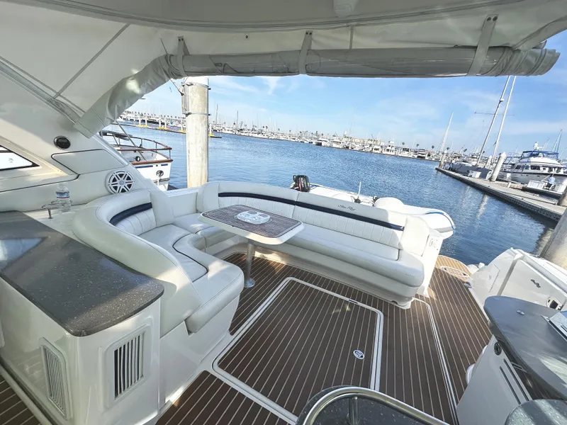 Slide: The Image of 2006 Sea Ray 48 Sundancer yacht with elegant seating, docked at a marina. - 7