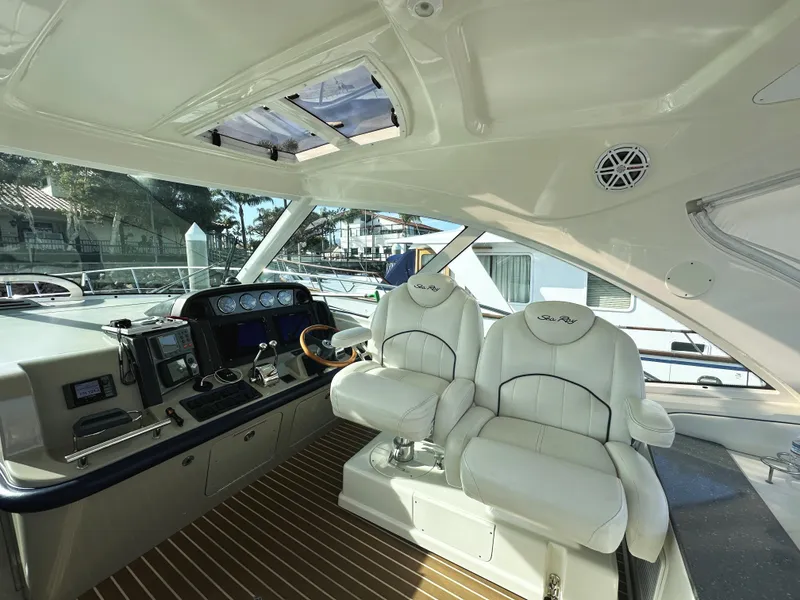 Slide: The Image of 2006 Sea Ray 48 Sundancer helm with dual white captain chairs and modern controls. - 9
