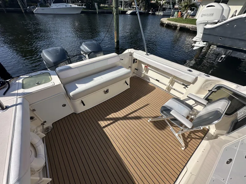 Slide: The Image of 2008 Pursuit 315 Offshore boat with spacious deck and seating, docked by the water. - 15