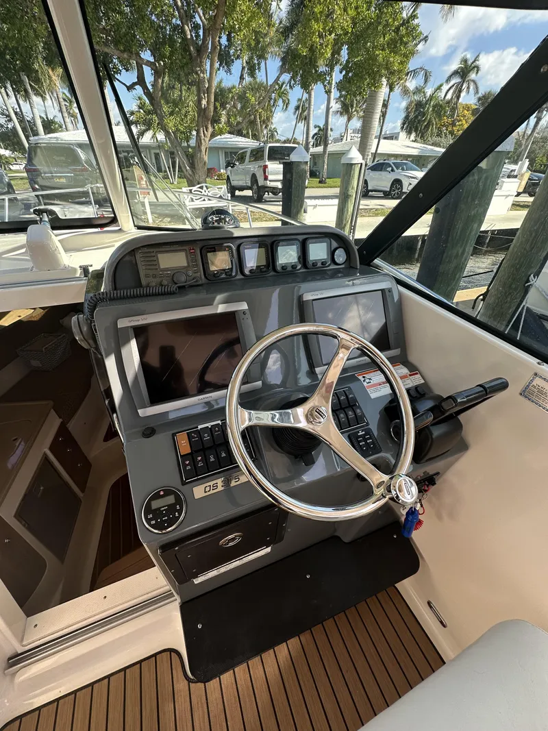 Slide: The Image of 2008 Pursuit 315 Offshore boat cockpit with steering wheel and navigation controls. - 17