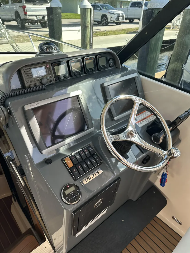 Slide: The Image of Control panel of a 2008 Pursuit 315 Offshore boat with steering wheel and navigation screens. - 18