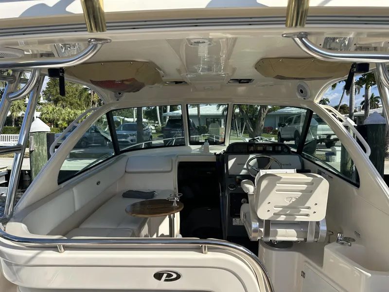Slide: The Image of 2008 Pursuit 315 Offshore boat interior with seating and helm, docked at marina. - 26