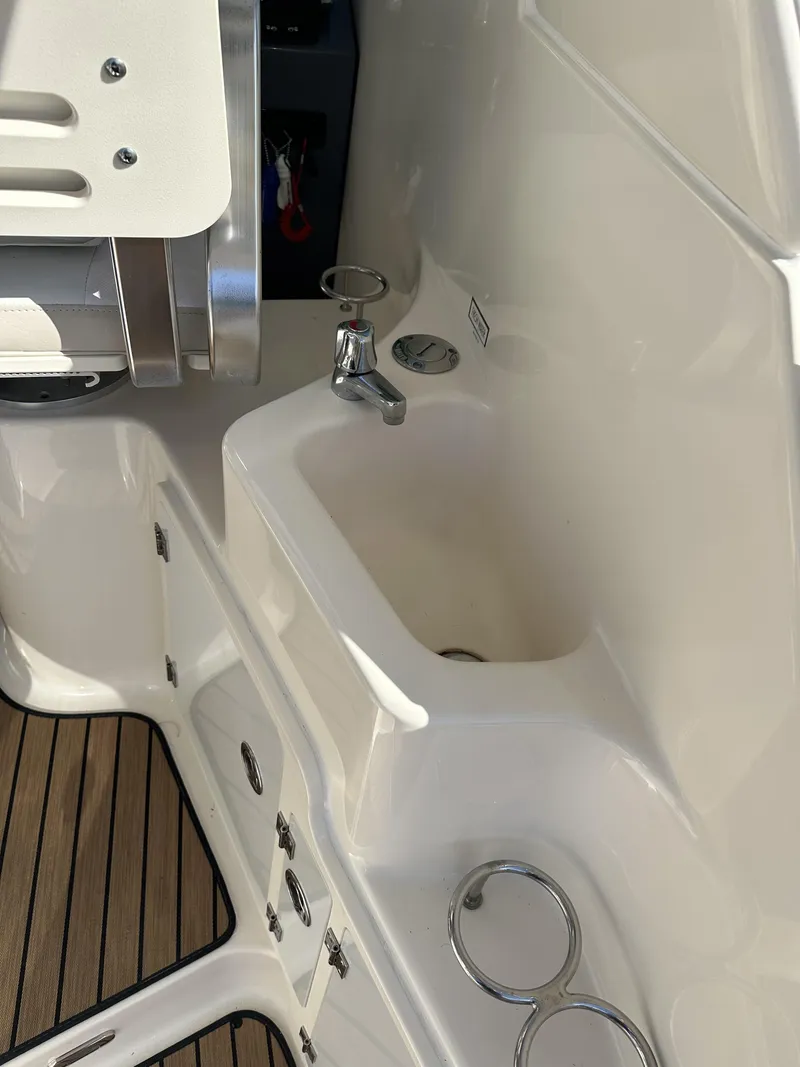 Slide: The Image of 2008 Pursuit 315 Offshore boat interior with sink and storage compartments. - 27