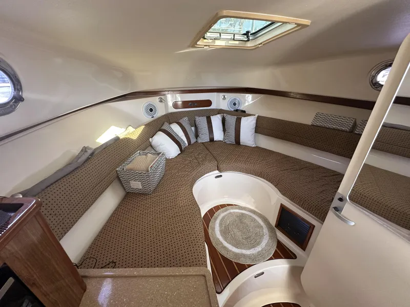 Slide: The Image of 2008 Pursuit 315 Offshore cabin interior with cushioned seating and portholes. - 31