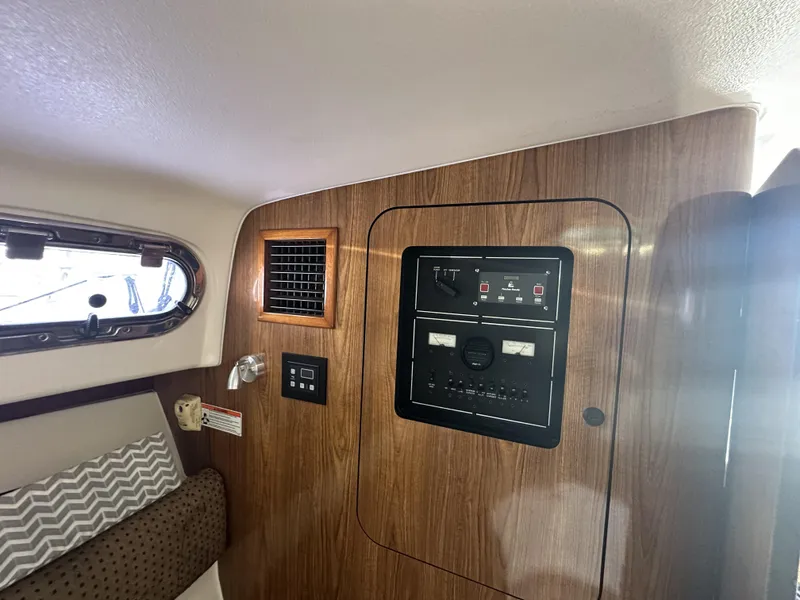 Slide: The Image of 2008 Pursuit 315 Offshore cabin interior with control panel and wood finish. - 32