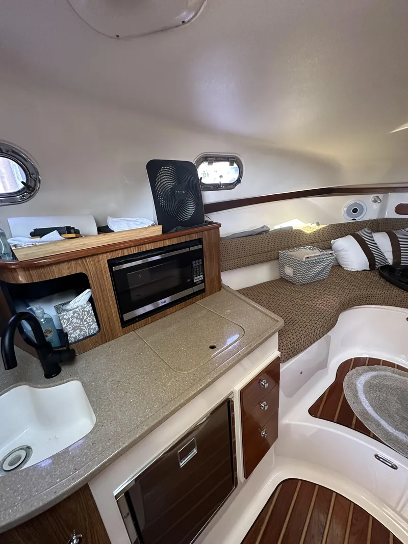 Slide: The Image of 2008 Pursuit 315 Offshore cabin interior with kitchenette and seating area. - 35