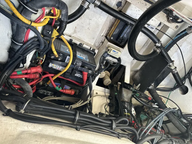 Slide: The Image of Engine compartment of a 2008 Pursuit 315 Offshore boat, showing wiring and batteries. - 49