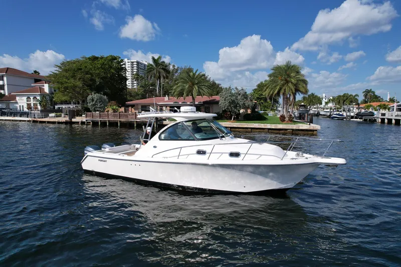 Slide: The Image of 2008 Pursuit 315 Offshore boat on a sunny day, dockside with palm trees. - 5