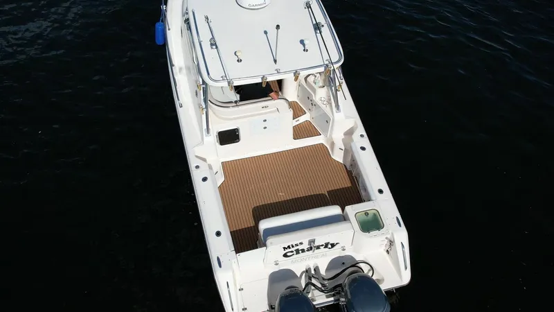 Slide: The Image of 2008 Pursuit 315 Offshore boat on water, aerial view, white exterior, spacious deck. - 8