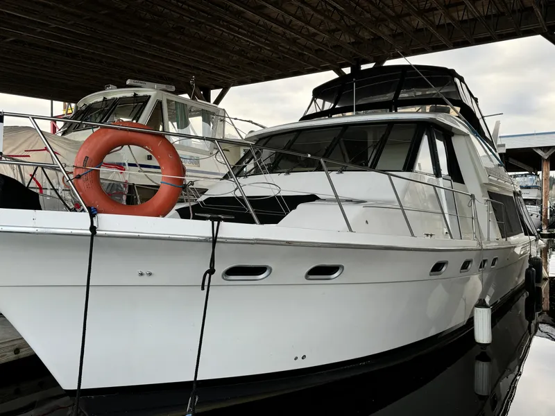 The Image of 1995 Bayliner 4788 yacht docked under a covered marina, featuring a life preserver. - 0