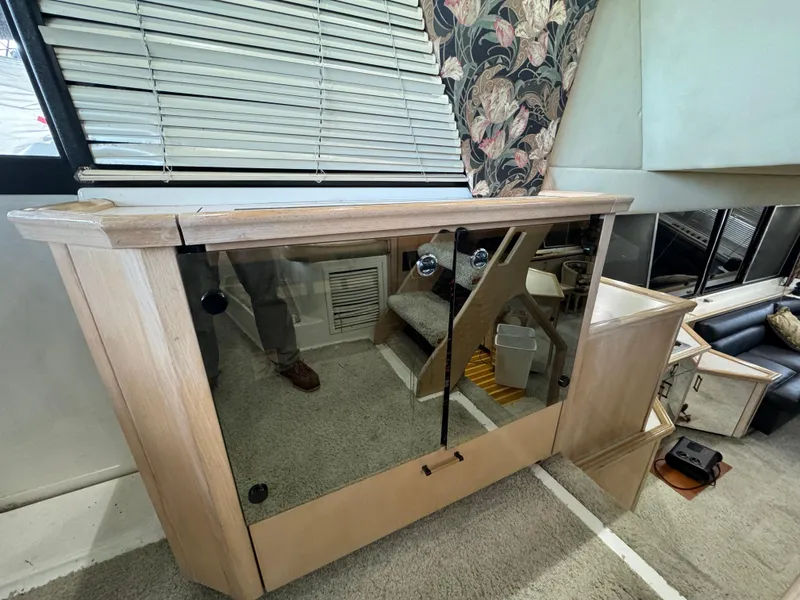 Slide: The Image of Interior of 1995 Bayliner 4788 yacht with glass cabinet and floral curtains. - 17