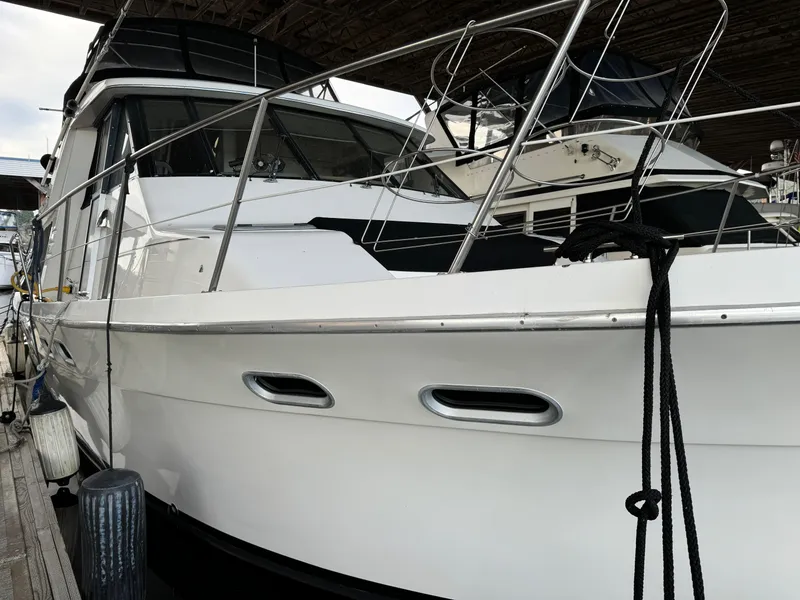 Slide: The Image of 1995 Bayliner 4788 yacht docked, showcasing sleek design and polished exterior. - 2