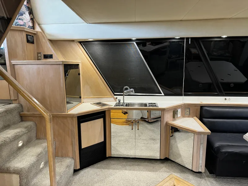 Slide: The Image of Interior of a 1995 Bayliner 4788 yacht featuring a compact kitchen area with modern amenities. - 22