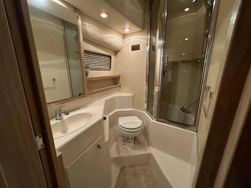 Slide: The Image of Bathroom interior of 1995 Bayliner 4788 yacht, featuring sink, toilet, and shower. - 35