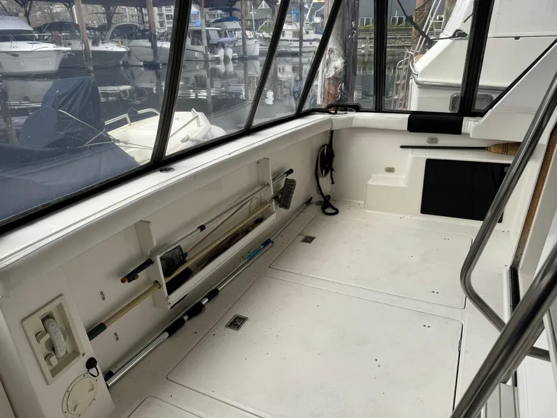 Slide: The Image of 1995 Bayliner 4788 cockpit with fishing gear, docked at marina. - 4