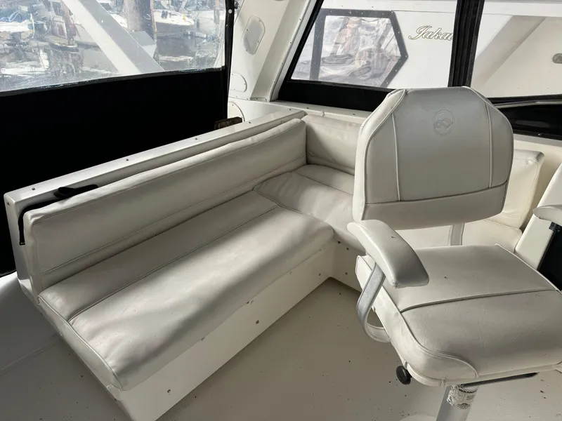 Slide: The Image of Interior of a 1995 Bayliner 4788 yacht with white leather seating and captain's chair. - 8