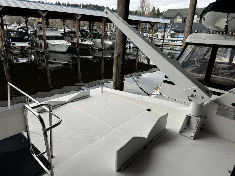 Slide: The Image of 1995 Bayliner 4788 yacht docked in marina, featuring spacious deck and davit crane. - 9