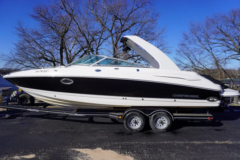 The Image of 2006 Chaparral 280SSi boat on trailer, parked outdoors, clear sky background. - 0