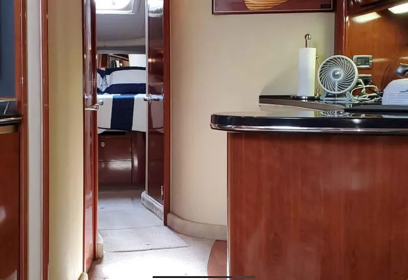 Slide: The Image of Interior of 2004 Sea Ray 500 Sundancer yacht, featuring a cozy cabin and kitchenette. - 11