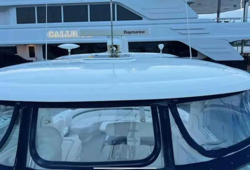 Slide: The Image of 2004 Sea Ray 500 Sundancer yacht with sleek design, docked near another vessel. - 3