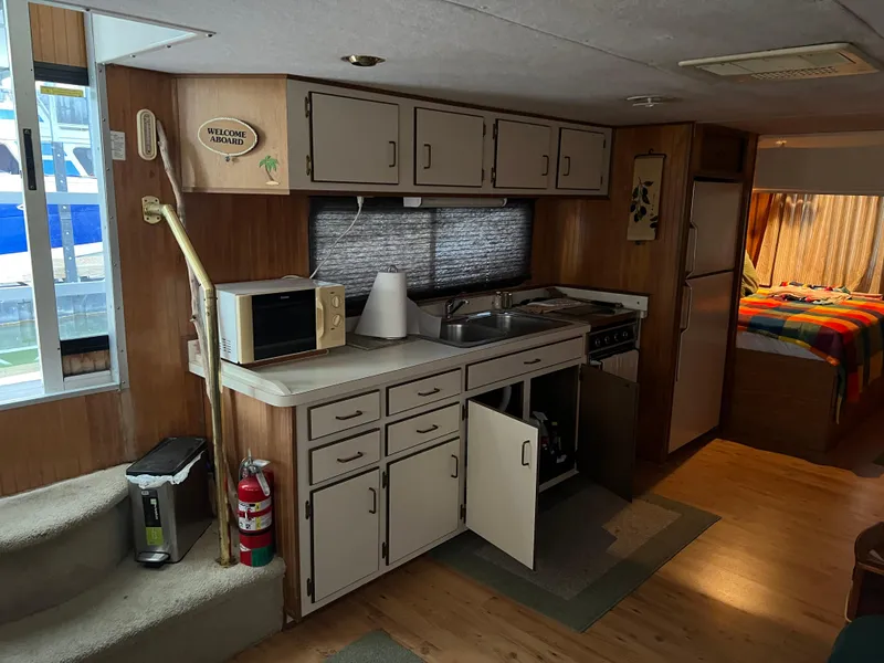 Slide: The Image of Interior of a 1996 Gibson 41 Sunsport boat with kitchen and cozy bedroom. - 11