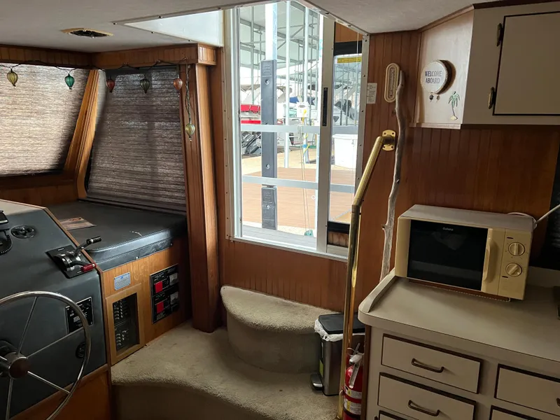 Slide: The Image of Interior of 1996 Gibson 41 Sunsport boat with helm, microwave, and stairs. - 12