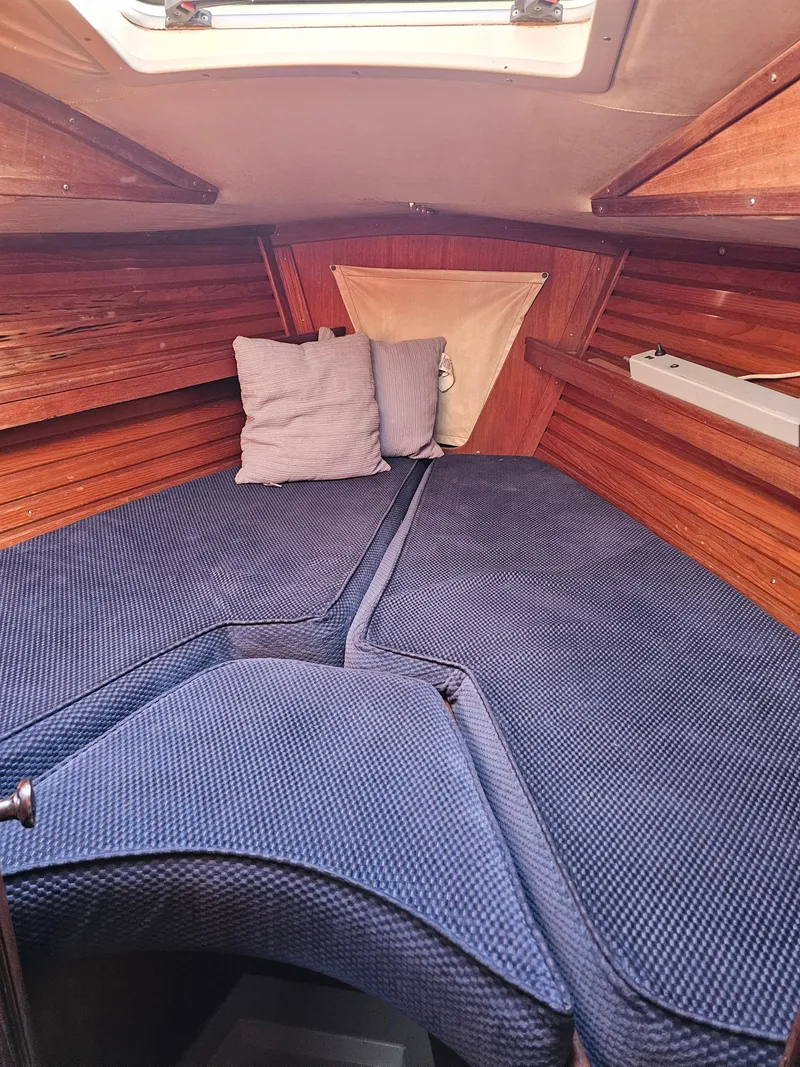 Slide: The Image of Cozy cabin interior of 1984 Schock NY 36 sailboat with blue cushions and wooden paneling. - 13