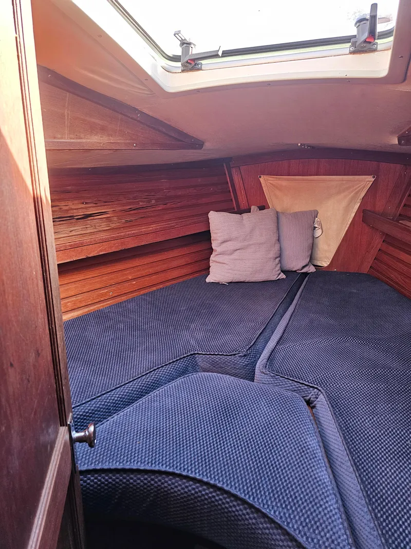 Slide: The Image of Cozy cabin interior of 1984 Schock NY 36 sailboat with blue cushions and wooden paneling. - 14