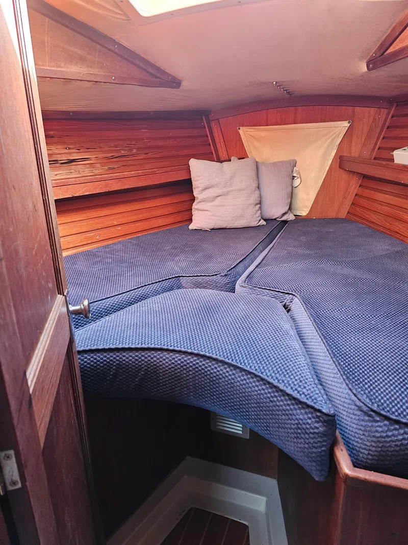 Slide: The Image of Cozy cabin interior of 1984 Schock NY 36 sailboat with blue bedding and wooden paneling. - 15