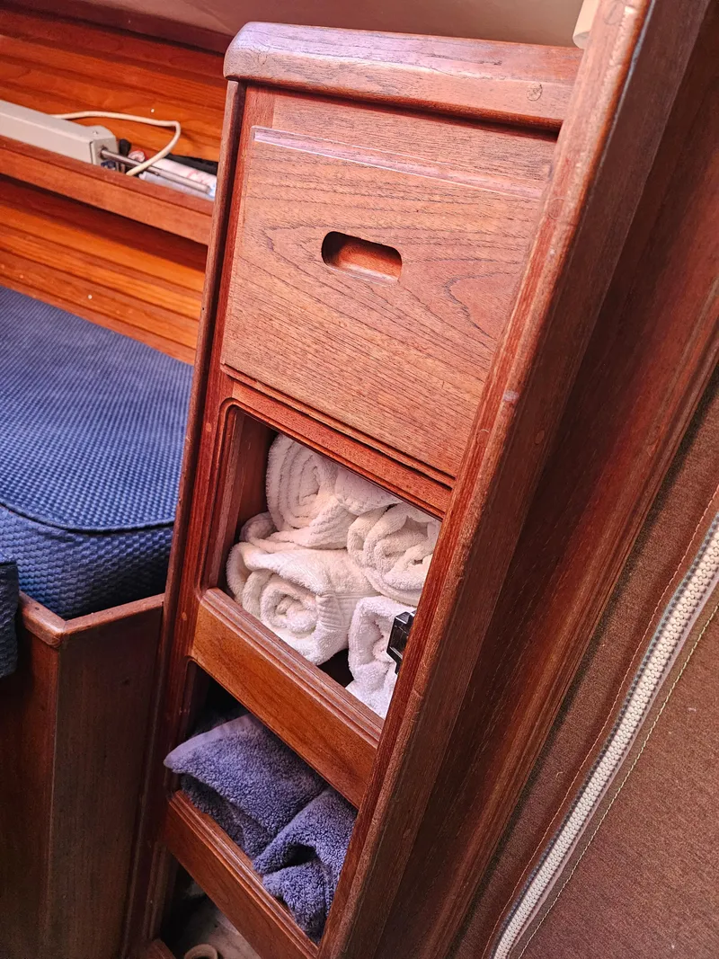 Slide: The Image of Wooden storage cabinet with towels inside a 1984 Schock NY 36 sailboat interior. - 16