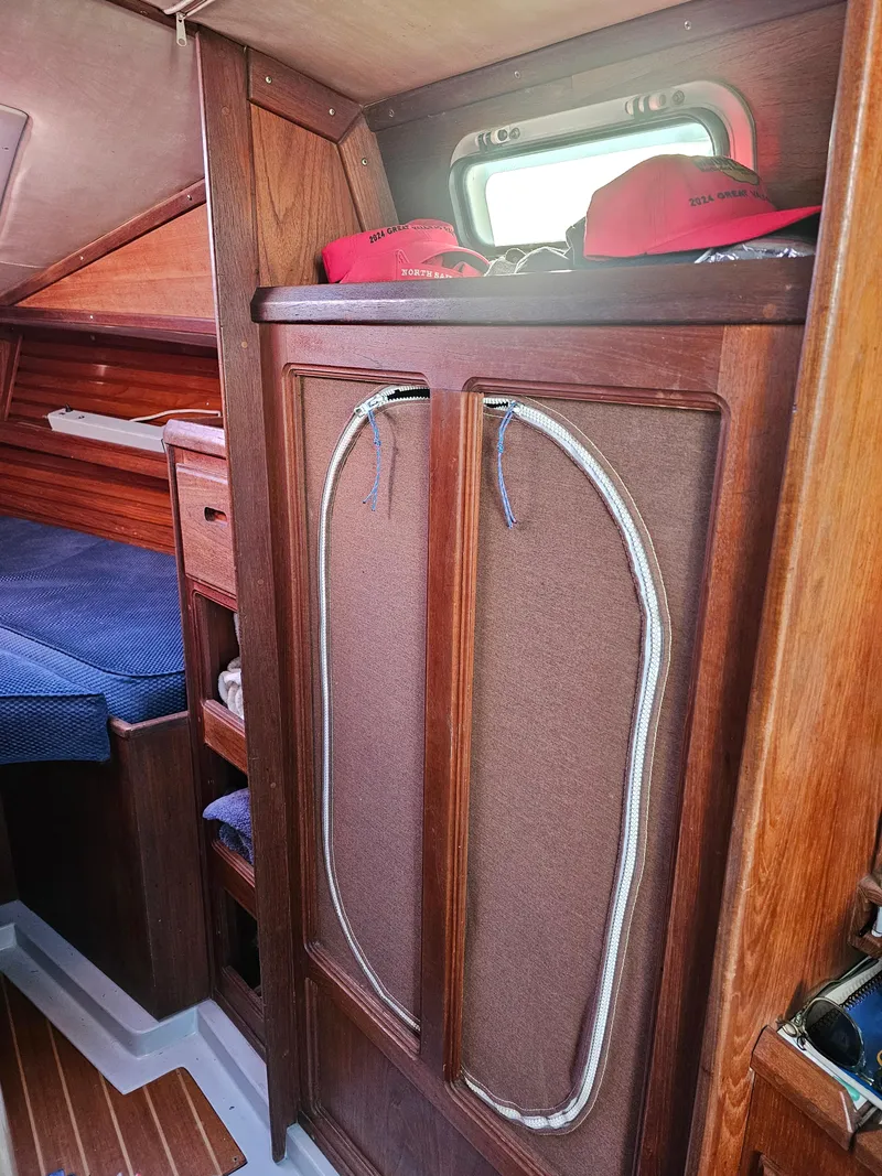 Slide: The Image of Interior of 1984 Schock NY 36 sailboat with wooden cabinetry and cozy sleeping area. - 17