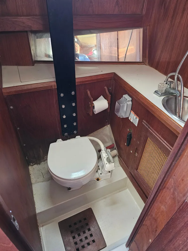 Slide: The Image of 1984 Schock NY 36 boat bathroom with toilet, sink, and wooden interior. - 18