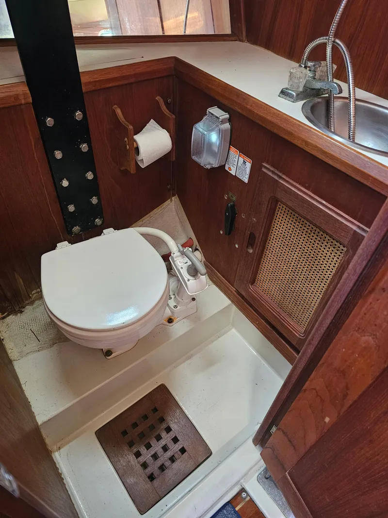 Slide: The Image of 1984 Schock NY 36 boat bathroom with toilet, sink, and wooden cabinetry. - 20