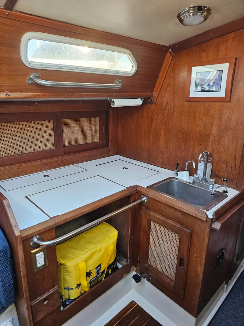 Slide: The Image of 1984 Schock NY 36 yacht interior galley with wood finish, sink, and storage. - 21