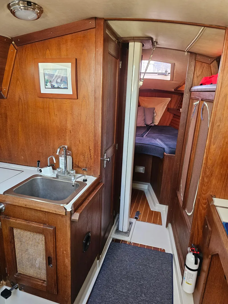 Slide: The Image of Interior of 1984 Schock NY 36 sailboat with wooden cabinetry and cozy sleeping area. - 22