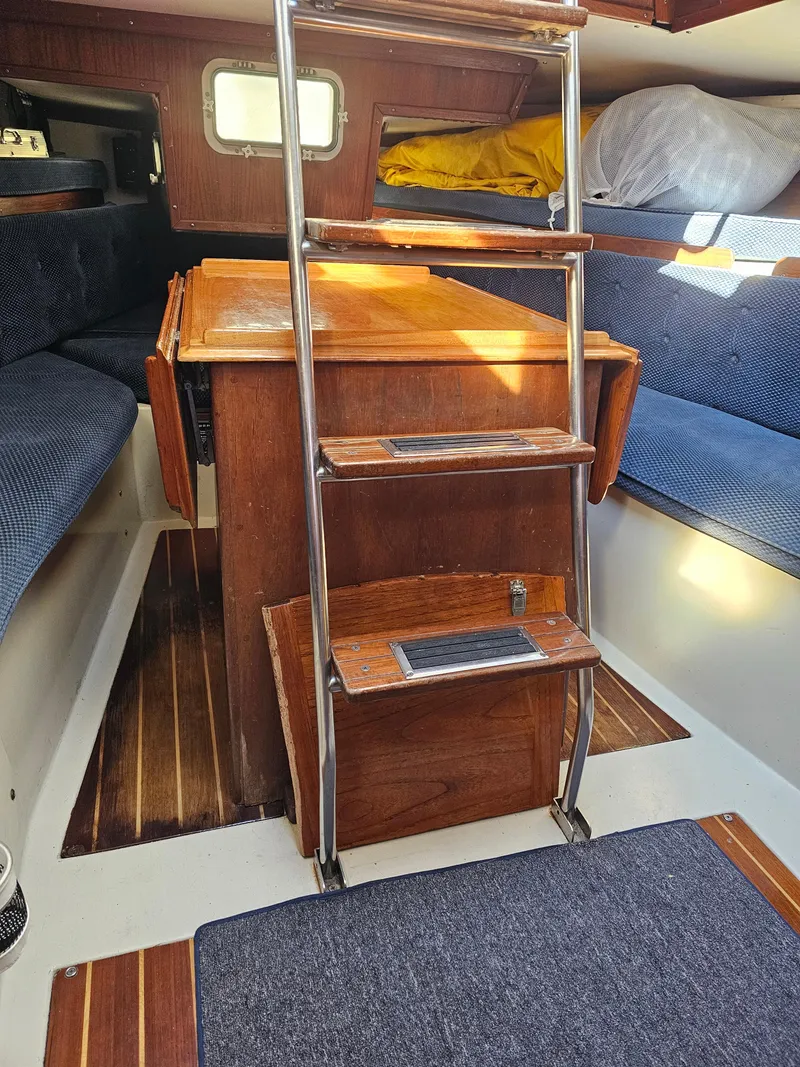 Slide: The Image of Interior of 1984 Schock NY 36 sailboat with wooden steps and blue seating. - 27
