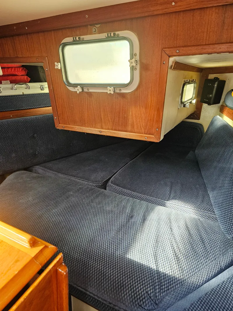 Slide: The Image of Cozy cabin interior of 1984 Schock NY 36 sailboat with blue cushions and wooden accents. - 28