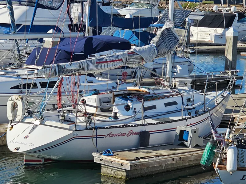 Slide: The Image of 1984 Schock NY 36 sailboat docked in a marina, surrounded by other boats. - 3