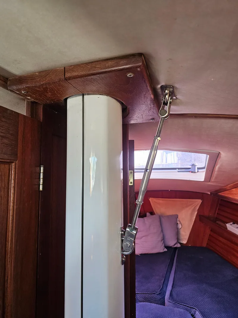Slide: The Image of Interior of a 1984 Schock NY 36 sailboat, featuring a mast support and cozy cabin area. - 30