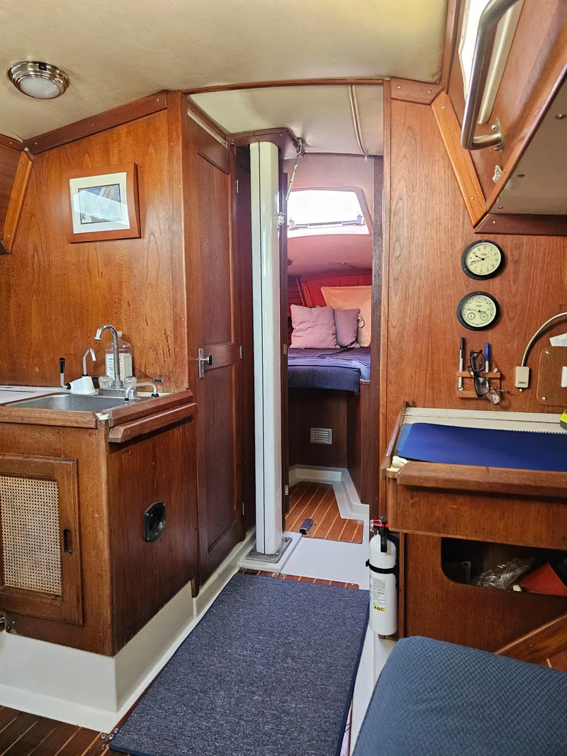 Slide: The Image of 1984 Schock NY 36 yacht interior with wood finish, kitchenette, and cozy sleeping area. - 38