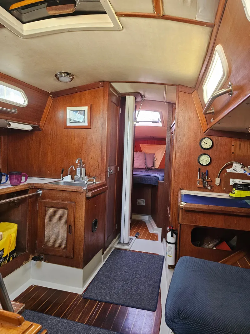 Slide: The Image of Interior of 1984 Schock NY 36 sailboat, featuring wood paneling and compact living space. - 39